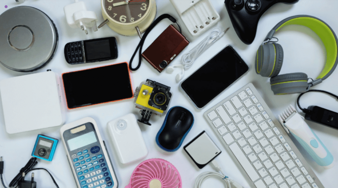 Flat lay of assorted refurbished electronics including smartphones, keyboard, headphones, and gadgets