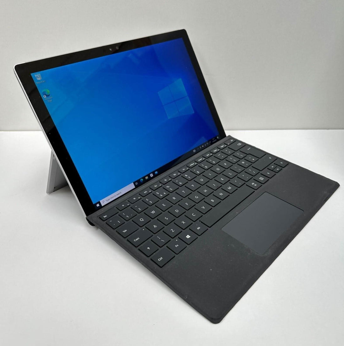 Refurbished black keyboard tablet laptop with Windows 10 open on white background