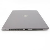 Closed slim silver laptop with HP logo, showing side vents and ports on white background.