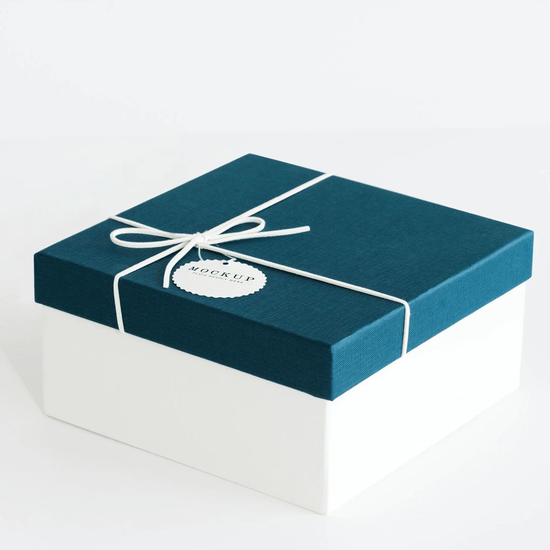 Gift box with teal lid, white base, and white ribbon on a plain background