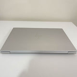 Closed silver HP EliteBook laptop on a white table, slim and professional design