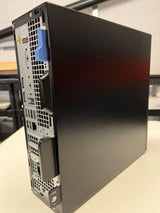 Refurbished desktop computer tower with rear ports and side panel visible, on a table